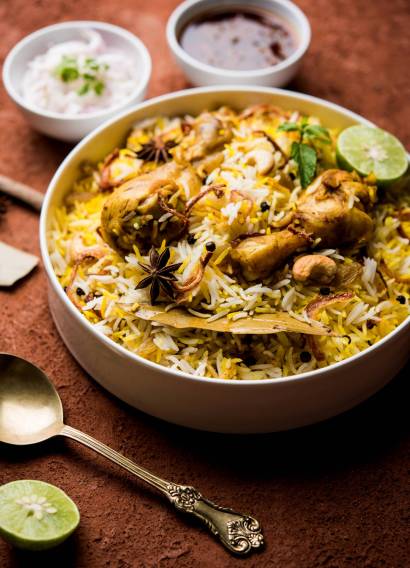 Delicious spicy chicken biryani in bowl over moody background, it’s a popular Indian and Pakistani food.